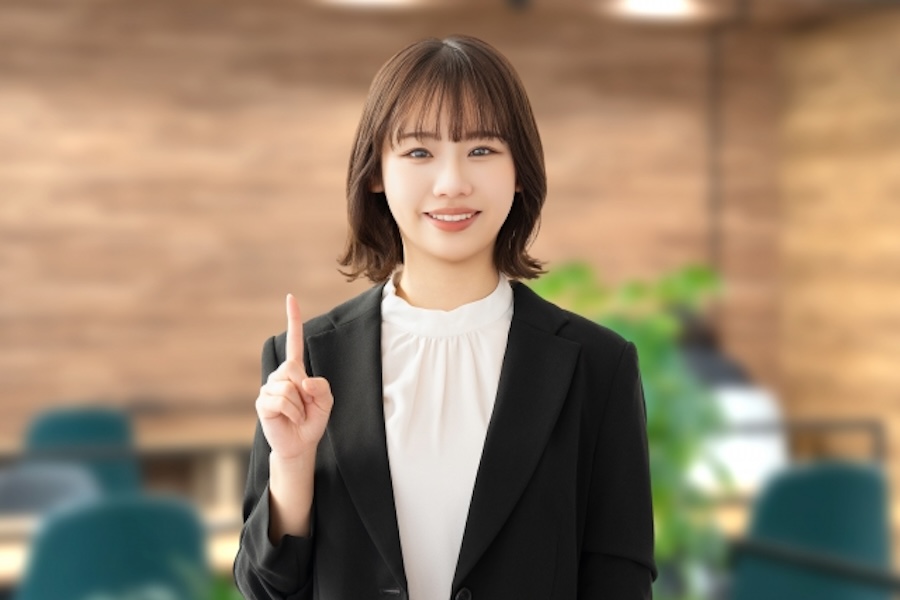 指を指し示す女性の画像