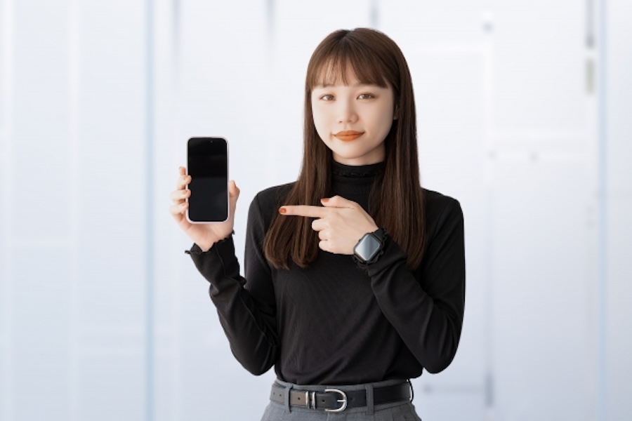 スマホを持つ女性の画像